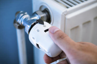 Hånd som justerer termostat på radiator